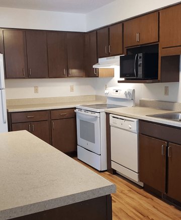 Cottage Grove townhouse for rent - an empty kitchen with white appliances and wooden cabinets