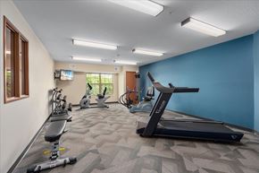 Mahtomedi apartment for rent - A spacious gym with a variety of equipment including treadmills, exercise bikes, and weights.