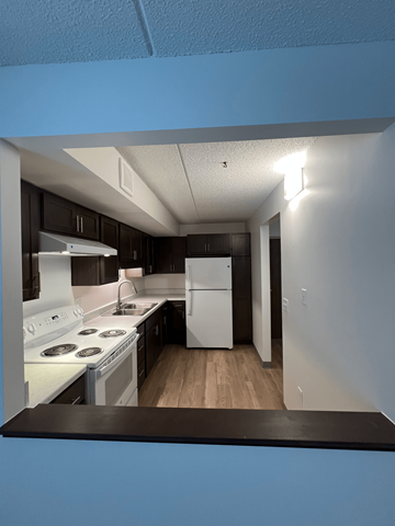 Stillwater townhouse for rent - A kitchen with a white stove top oven and a white refrigerator.