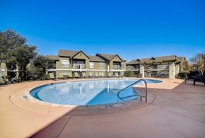 San Antonio apartment for rent - La Mirage in San Antonio resort-style pool with lounge chairs and nearby pergola.