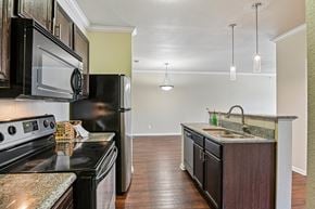 Fort Worth apartment for rent - A kitchen with black appliances and a granite countertop.