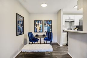 Austin apartment for rent - A dining area with a white furry bench and blue chairs.