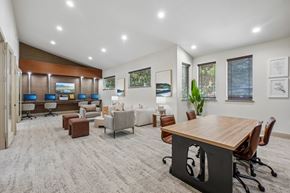 Dallas apartment for rent - A modern office space with a variety of seating options and a long wooden table.