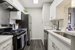Austin apartment for rent - A kitchen with a black stove top oven and white cabinets.