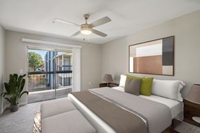 Oklahoma City apartment for rent - A bedroom with a large bed and a ceiling fan.