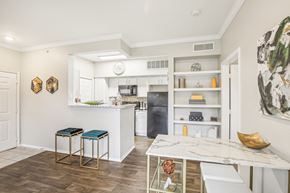 Houston apartment for rent - A kitchen with a white counter top and bar stools.