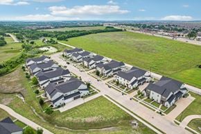 Princeton triplex for rent - A large, well-maintained housing development with multiple houses and a spacious green field.
