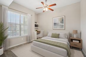 Lewisville apartment for rent - A bedroom with a large bed and a ceiling fan.