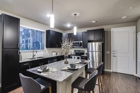 Conroe apartment for rent - a kitchen with a large island with a granite countertop