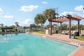 Venice apartment for rent - A pool with a pergola and palm trees in the background.