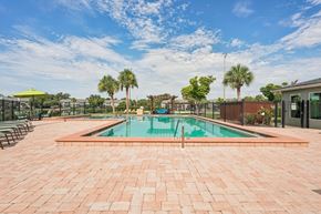 Venice apartment for rent - A pool surrounded by a brick patio with trees in the background.