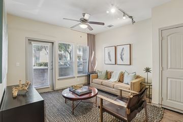 Farmers Branch apartment for rent - A living room with a black coffee table and a brown chair.