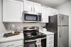 Hendersonville apartment for rent - A modern kitchen with white cabinets and stainless steel appliances.