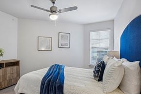 Garland apartment for rent - A bedroom with a bed covered in a blue blanket and two pillows.
