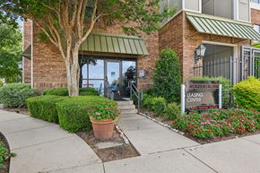 Fort Worth apartment for rent - A leasing center sign is in front of a building with a brick facade and a green awning.