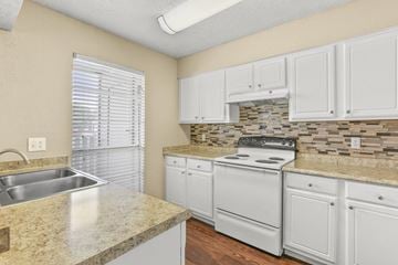 Bedford apartment for rent - A kitchen with white cabinets and a granite countertop.