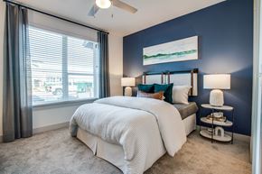 Burleson apartment for rent - Bedroom with blue accent wall, ceiling fan, and large window for daylight.