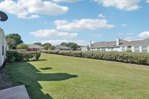 Waxahachie townhouse for rent - A grassy area with a building in the background.