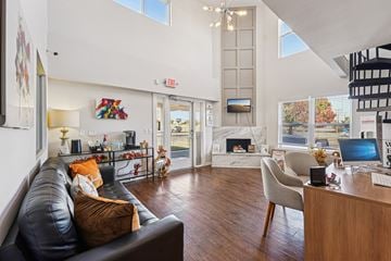 Oklahoma City apartment for rent - A black leather couch with a brown pillow sits in a living room.
