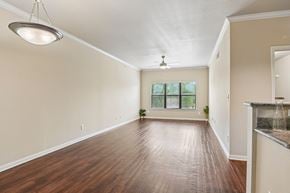 Fort Worth apartment for rent - A spacious room with wooden floors and a ceiling fan.