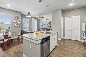 Waxahachie apartment for rent - A kitchen with a large island and a dining table with chairs.