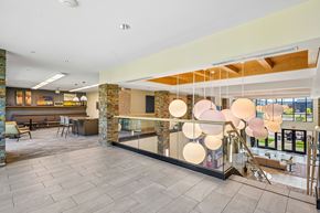 Forney apartment for rent - A modern interior space with a stone wall and a glass barrier.
