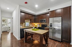 Dallas apartment for rent - A kitchen with a table and a fridge.