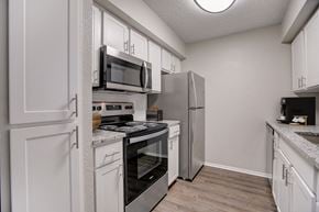 Austin apartment for rent - a kitchen with stainless steel appliances and white cabinets