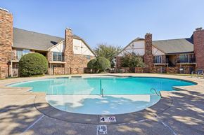 Oklahoma City apartment for rent - A swimming pool surrounded by a brick building.