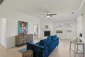Waxahachie townhouse for rent - A living room with a blue couch and a painting on the wall.