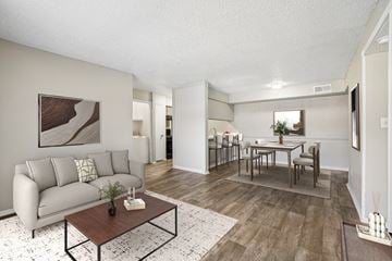 Mesquite apartment for rent - A living room with a grey couch, a coffee table, and a dining table with chairs.