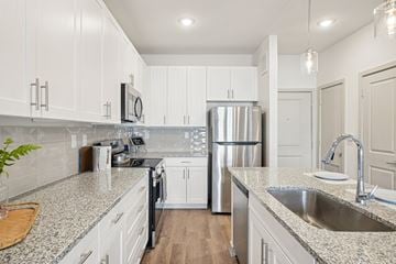 Elgin apartment for rent - A kitchen with white cabinets and a granite countertop.