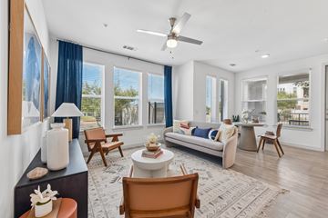 Pflugerville apartment for rent - A living room with a couch, chairs, and a table with a vase on it.