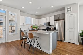 Fort Worth apartment for rent - A kitchen with white cabinets and a wooden floor.
