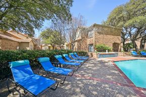 Richardson apartment for rent - A pool surrounded by blue lounge chairs.