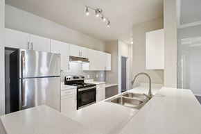 Austin apartment for rent - A modern kitchen with a stainless steel refrigerator and a sink.