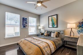 Lewisville apartment for rent - a bedroom with a large bed and a ceiling fan