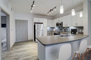 Forney apartment for rent - a kitchen with white cabinets and a counter top and a sink