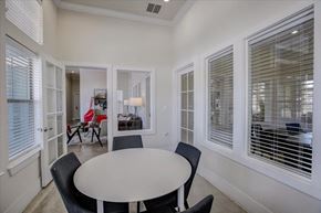 Kyle apartment for rent - Small meeting room with round table, upholstered chairs, and interior windows.