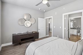 Waxahachie apartment for rent - A bedroom with a large bed and a wooden dresser.