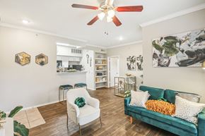 Houston apartment for rent - A living room with a green couch and a white chair.