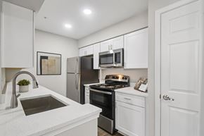 Oklahoma City apartment for rent - A modern kitchen with white cabinets and stainless steel appliances.