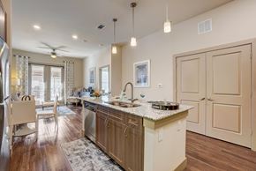 Euless apartment for rent - A kitchen with a large island and a refrigerator on the left.