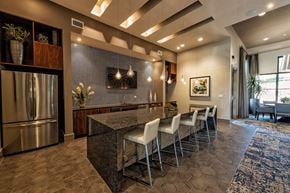 Austin apartment for rent - A modern kitchen with a refrigerator, island, and chairs.