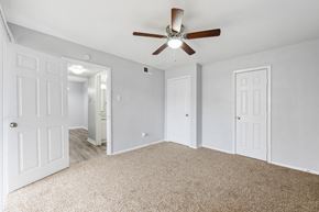 Denton apartment for rent - an empty bedroom with a ceiling fan and white doors