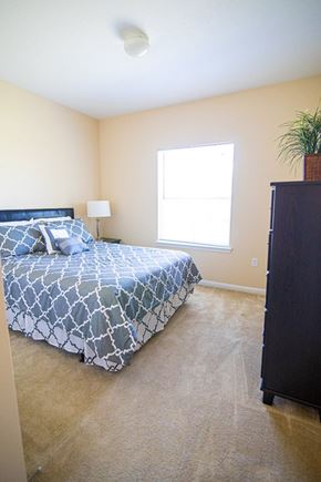 St. Marys apartment for rent - A bedroom with a bed, dresser, and window.