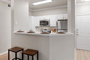 Carrollton apartment for rent - Open apartment kitchen with breakfast bar, white cabinets, and stainless appliances.