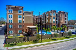 Houston apartment for rent - a building with a pool in front of a street