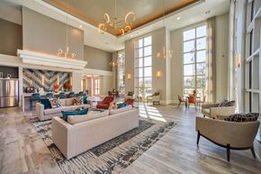 Houston apartment for rent - a spacious lobby with couches and chairs and a fireplace