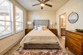 Houston apartment for rent - a bedroom with a bed and a ceiling fan